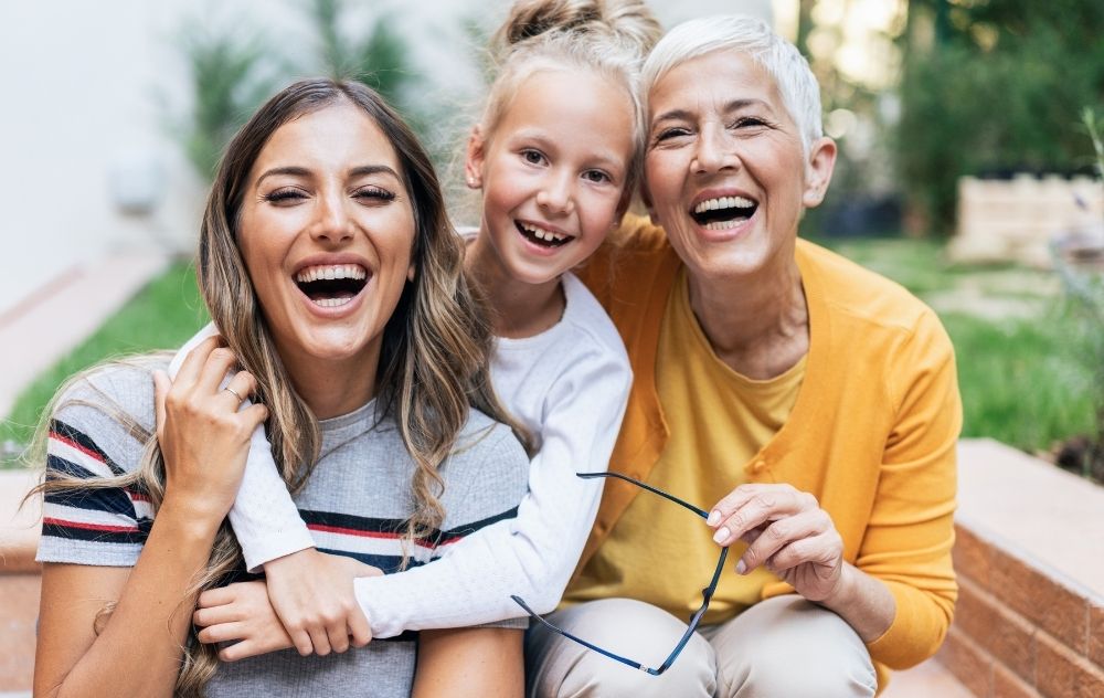 Three generations of women sitting together smiling